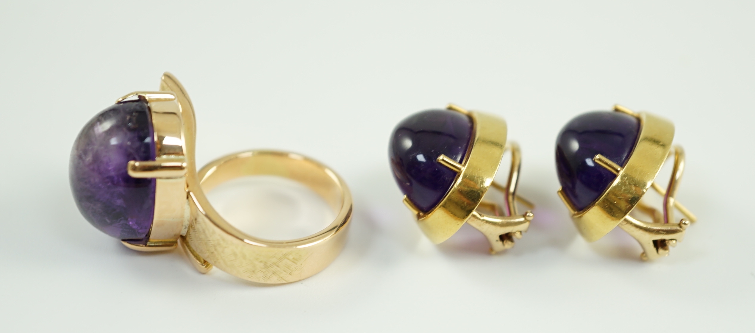 A modern gold and cabochon oval amethyst set dress ring and a pair of similar earrings